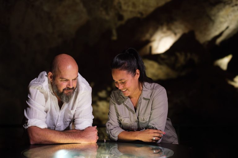 Two people looking at the fossil display inside Mamoth Cave