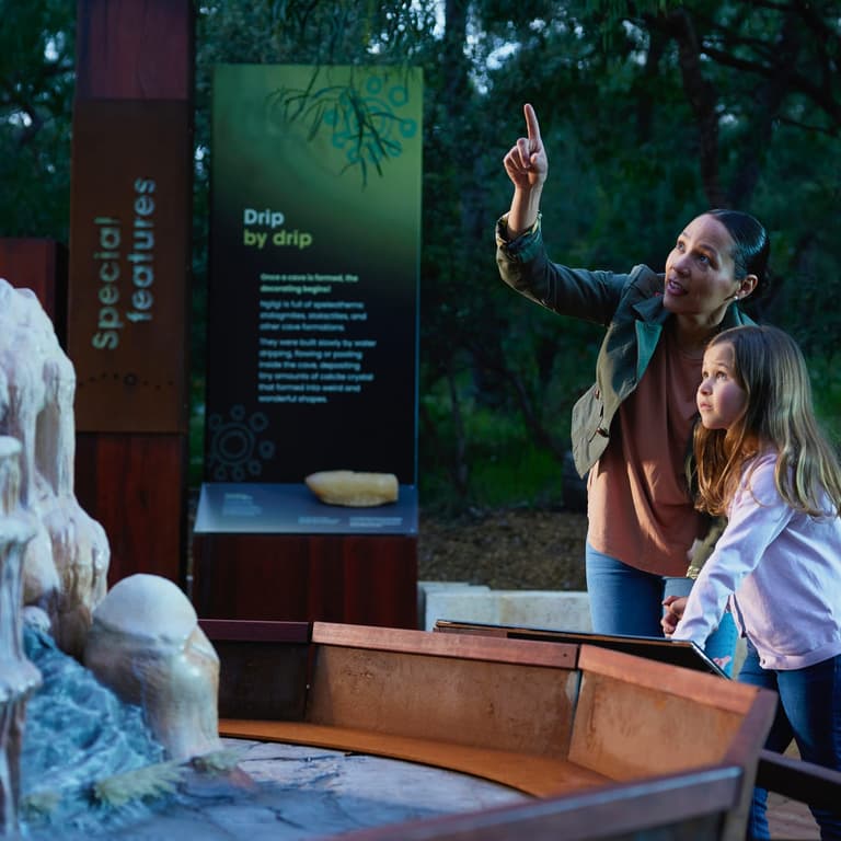woman and child looking and pointing at sculpture at Ancient Lands Experiene at Ngligi Cave.