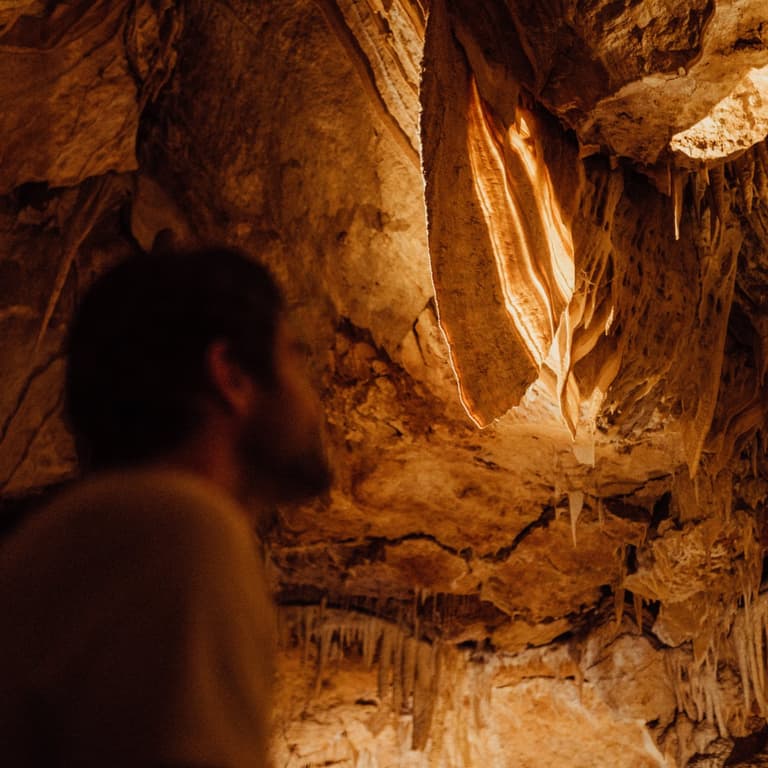 A visitor admiring a stunning, colourful shawl formation inside Ngilgi Cave