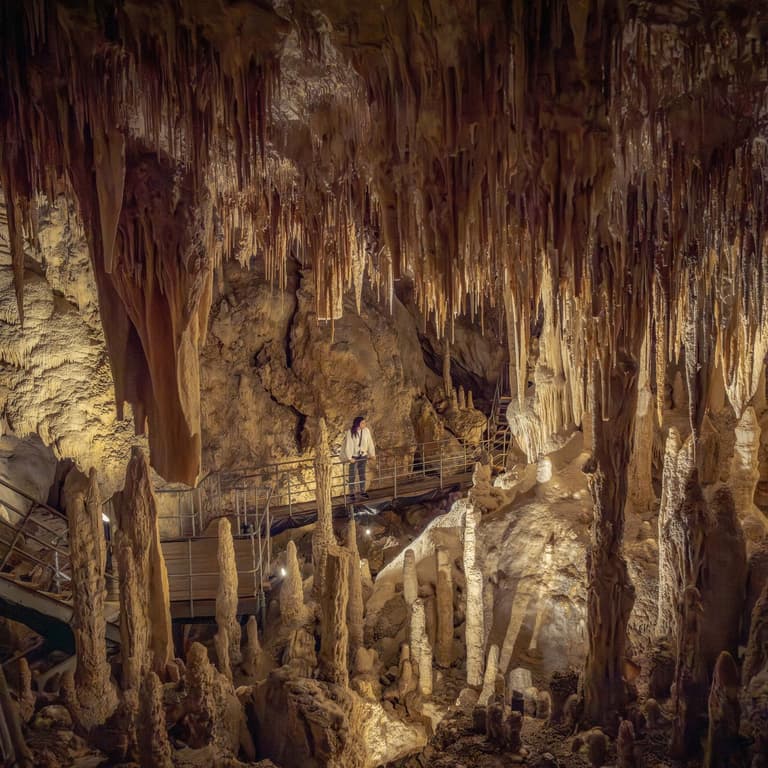 A person admiring the formations inside Mammoth Cave, listening to the audio guide via a headset
