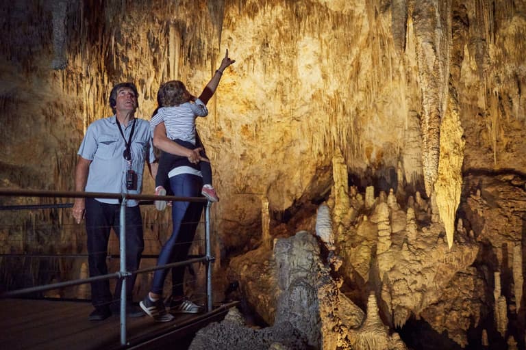 Young family looking at stalactites from a viewing platform inside Mammoth Cave
